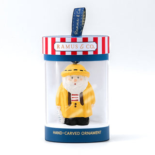 Santa fisherman hand-carved ornament inside a clear gift tube with blue base label.