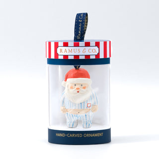 Santa ornament with white beard, blue striped pajamas, red hat; hangs from blue ribbon.