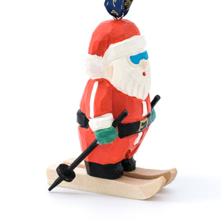Hand-carved ski Santa ornament standing on wooden skis, red coat, white beard, green mittens