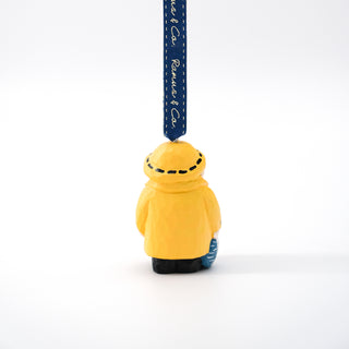 Hand-carved Santa fisherman ornament rear view with navy hanging ribbon and black boots.