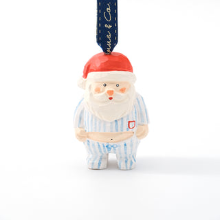 Carved Santa figurine ornament with red hat, white beard, and blue striped pajamas.