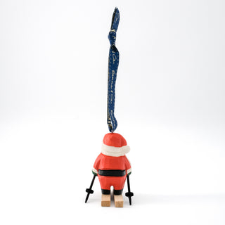 Hand-carved ski Santa ornament on wooden skis, red-and-white suit with black boots, hanging loop