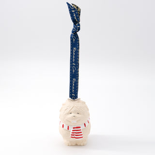 Carved yeti ornament with navy-blue ribbon, white face, and red striped shirt