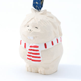Close-up carved yeti ornament: white face, red striped shirt, and blue ribbon