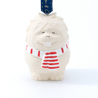Front view carved yeti ornament with white body, red striped shirt, and blue ribbon