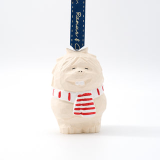 Carved yeti ornament with blue ribbon, white body, and red striped shirt on top